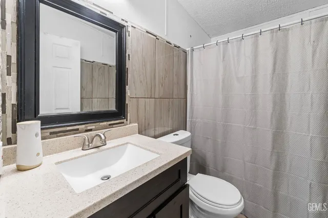 a bathroom with a sink vanity mirror and toilet