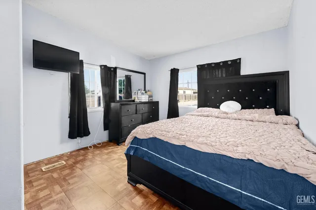 a large bedroom with a bed and a flat screen tv