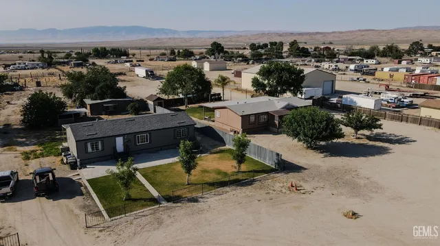 an aerial view of a house with a garden and mountain view