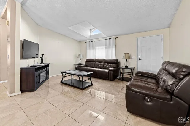 a living room with furniture a flat screen tv and a window