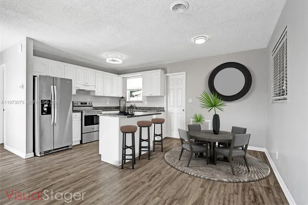 a kitchen with stainless steel appliances granite countertop a refrigerator and a stove top oven