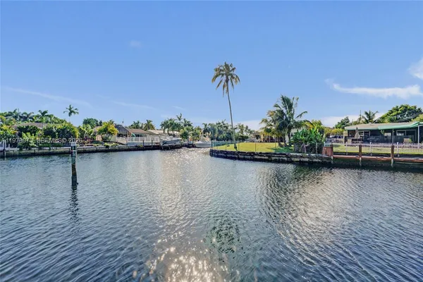 a view of a lake with boats and palm trees