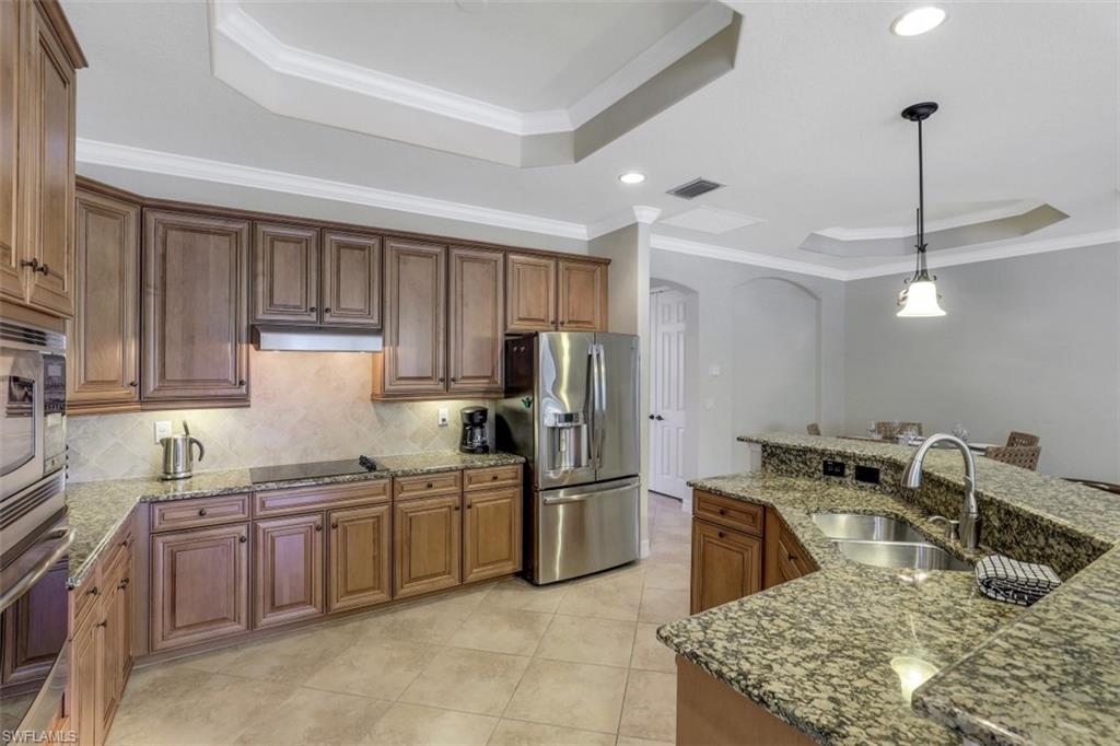 9530 Piacere Way Naples, FL 34113 - Photo 14 of 45 a kitchen with stainless steel appliances granite countertop a sink stove and refrigerator