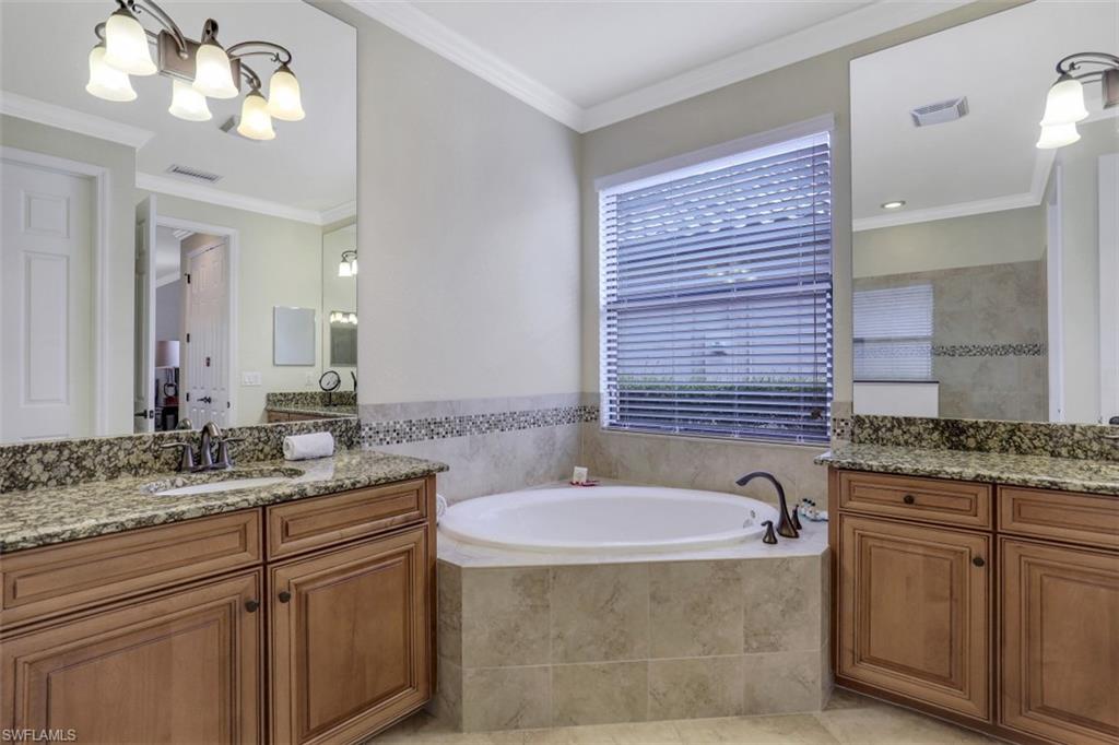 9530 Piacere Way Naples, FL 34113 - Photo 21 of 45 a bathroom with a granite countertop sink a large mirror and a bathtub
