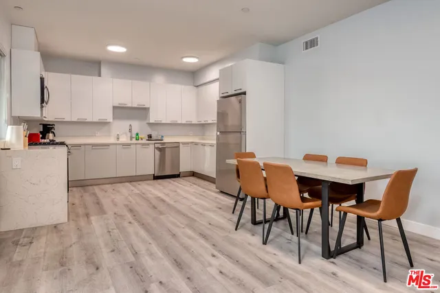 a kitchen with a table chairs sink and cabinets