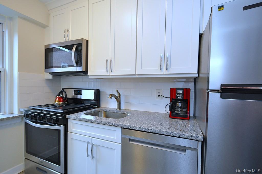 235 Garth Road, Unit A5B Scarsdale, NY 10583 - Photo 1 of 47 a kitchen with granite countertop a stove and a white cabinets
