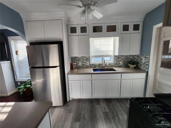 a kitchen with stainless steel appliances a refrigerator sink and cabinets