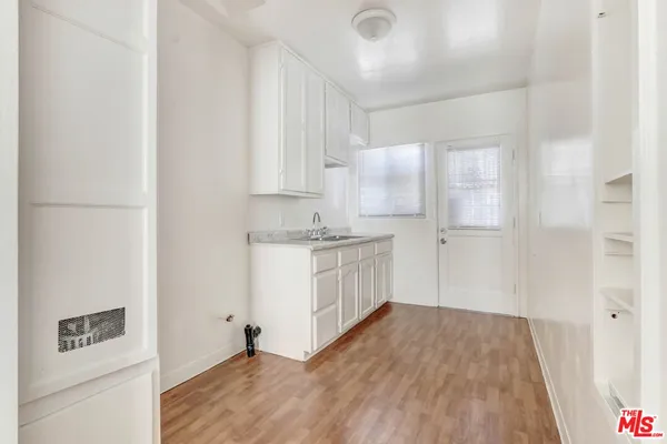 a kitchen with white cabinets and white appliances