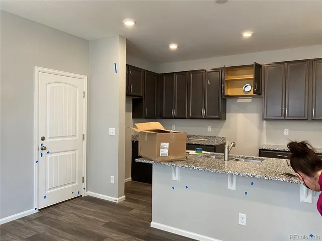 a kitchen with stainless steel appliances granite countertop a refrigerator a sink and wooden cabinets