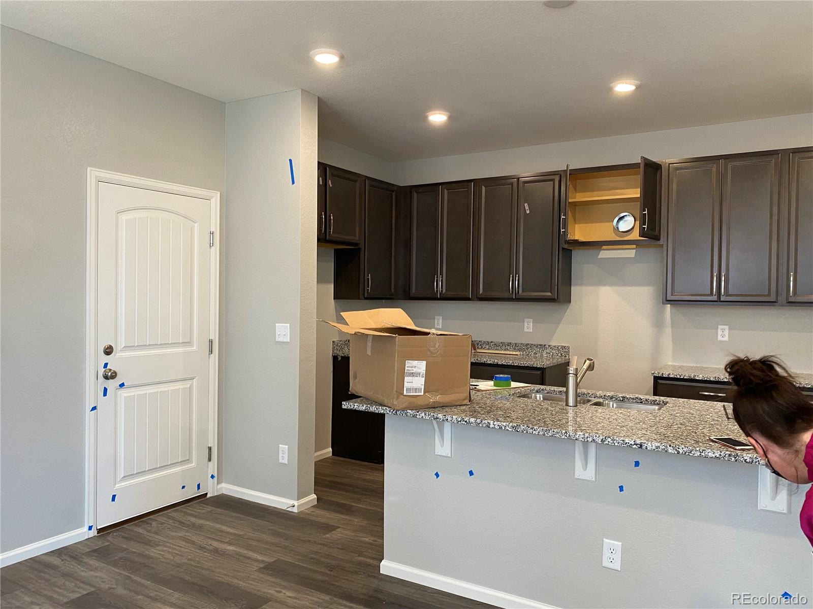 21250 East Radcliff Place Aurora, CO 80015 - Photo 3 of 11 a kitchen with stainless steel appliances granite countertop a refrigerator a sink and wooden cabinets