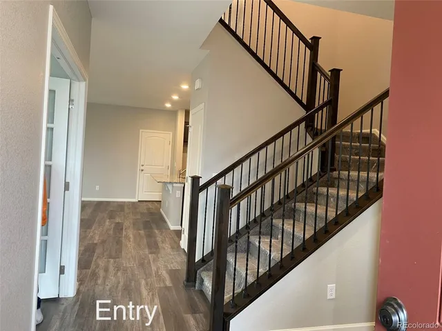 a view of staircase with railing and white walls