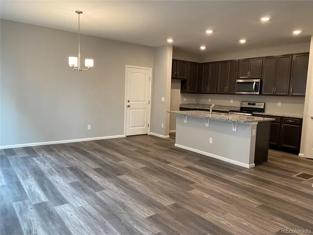 a kitchen with stainless steel appliances granite countertop a sink a stove and a refrigerator