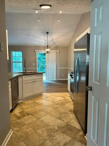 a kitchen with stainless steel appliances granite countertop a refrigerator and a stove