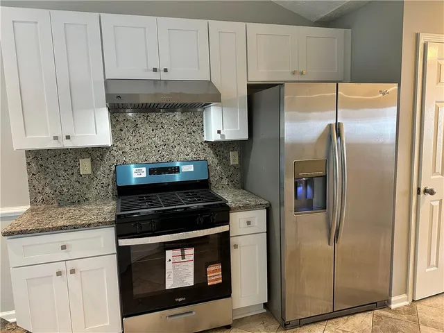 a kitchen with granite countertop a sink and cabinets