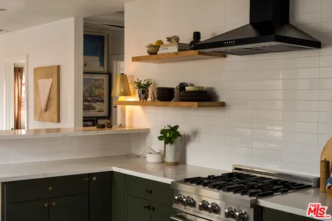 a stove top oven sitting inside of a kitchen