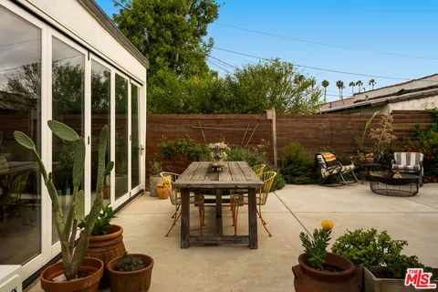 a backyard of a house with fountain table and chairs