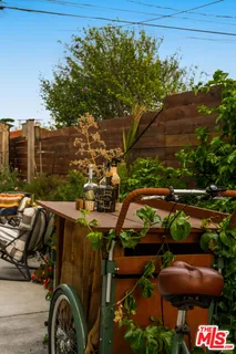 a view of a patio with table and chairs potted plants and a large tree
