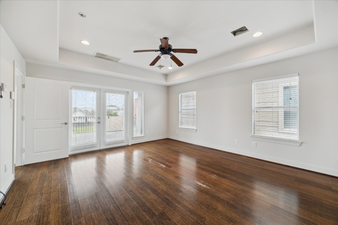 3041 Clinton Drive Houston, TX 77020 - Photo 16 of 29 an empty room with wooden floor chandelier fan and windows