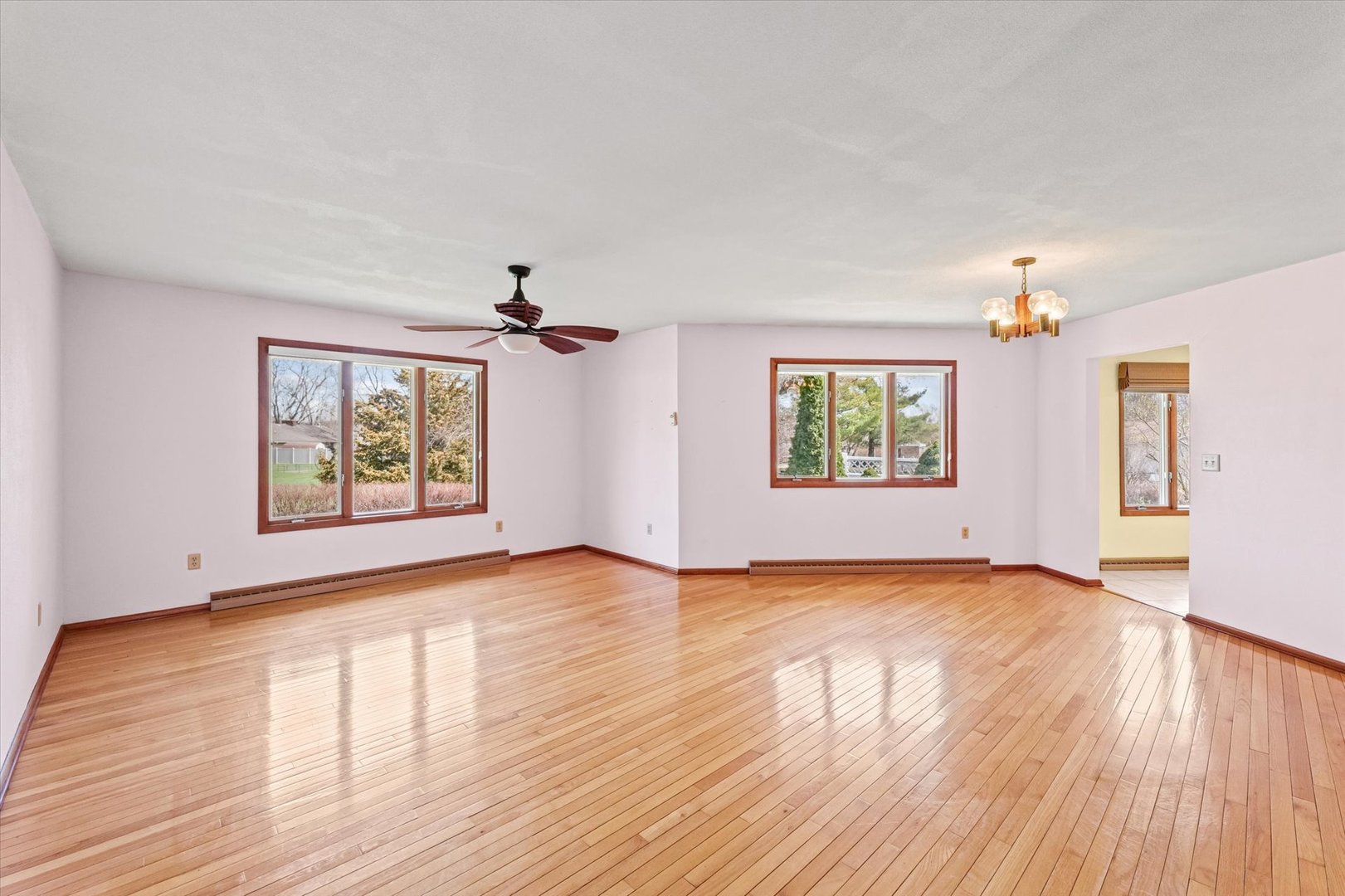 510 Parker Place Rantoul, IL 61866 - Photo 6 of 33 an empty room with wooden floor chandelier and windows