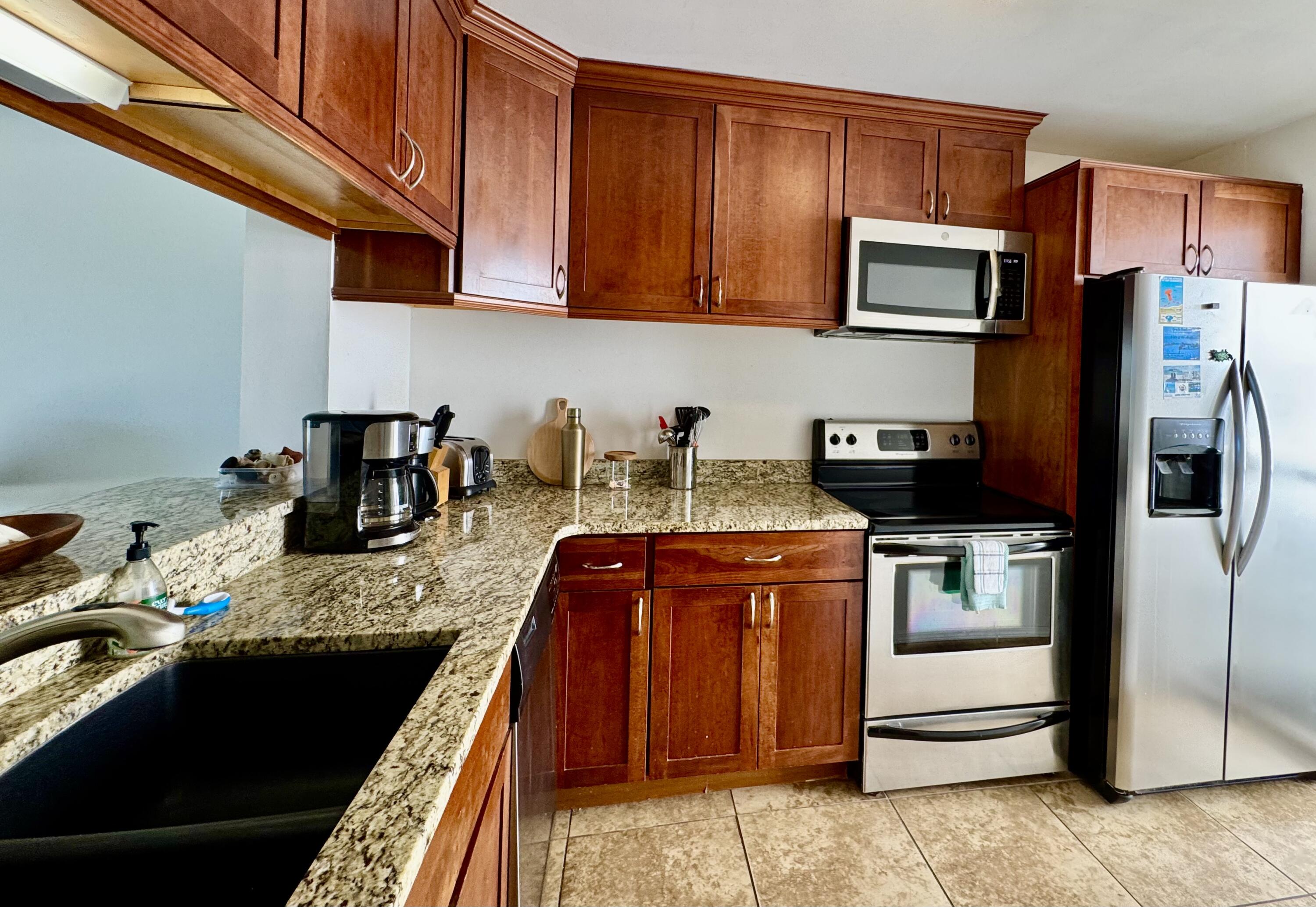 228 Walton Magnolia Lane, Unit 9 Inlet Beach, FL 32461 - Photo 7 of 24 a kitchen with stainless steel appliances granite countertop a refrigerator stove and sink