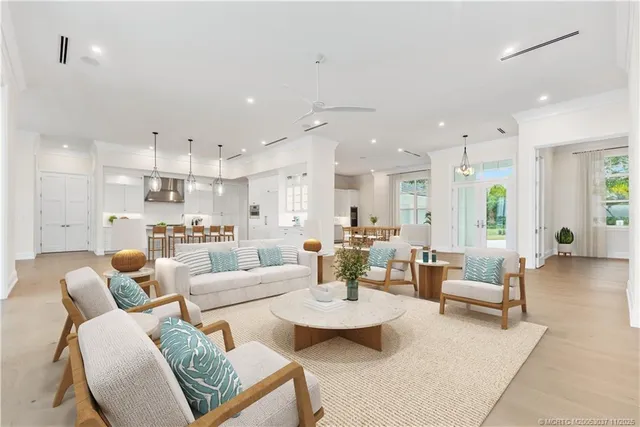 a living room with furniture and a dining table with kitchen view
