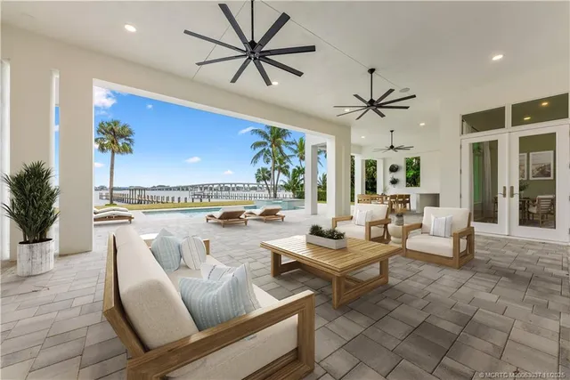 a living room with furniture a chandelier and a floor to ceiling window