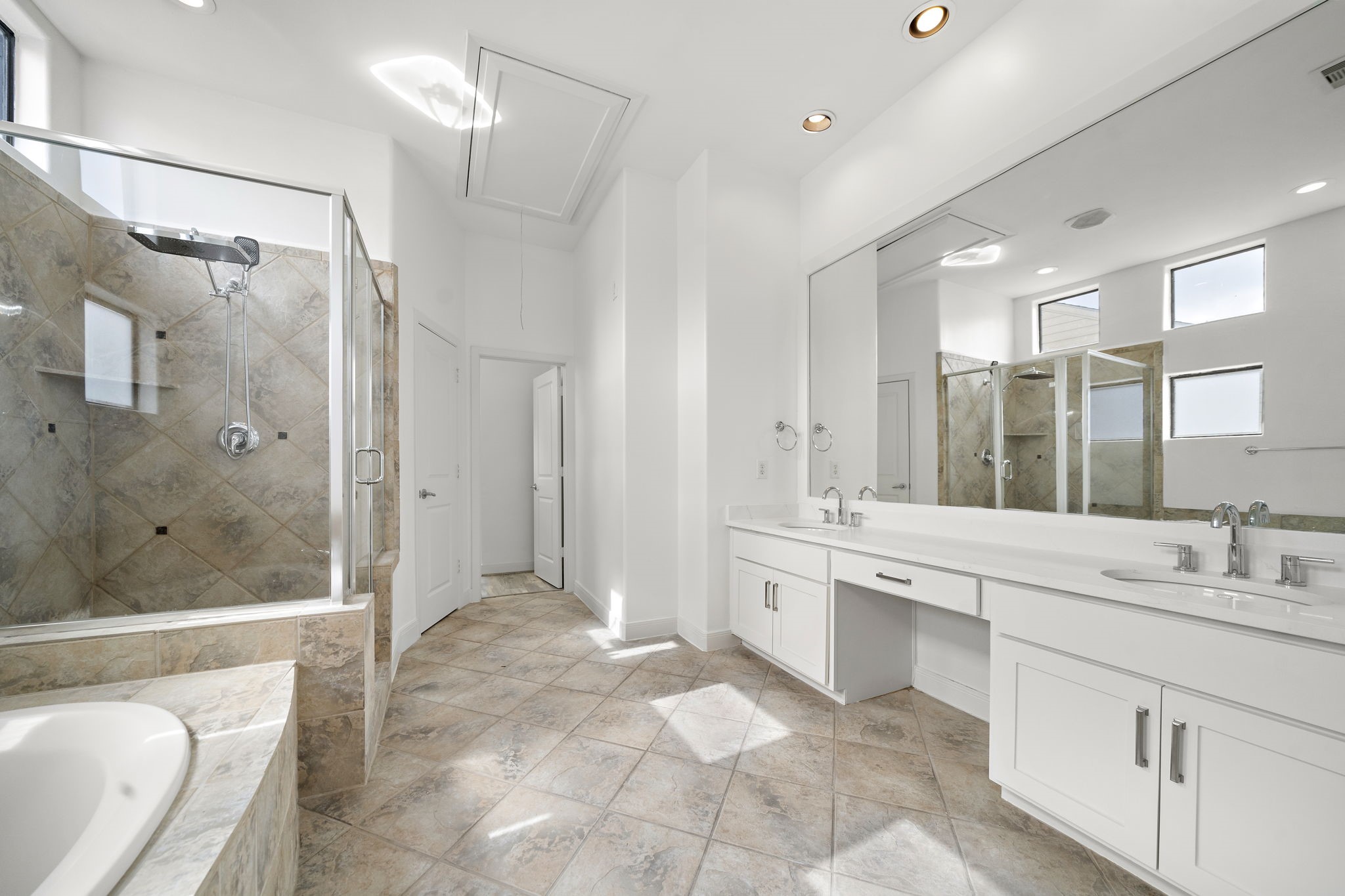 906 Reinerman Street Houston, TX 77007 - Photo 37 of 48 Discover a bright, modern bathroom featuring a spacious walk-in shower with sleek glass doors, a luxurious bathtub, and dual vanities with generous counter space.