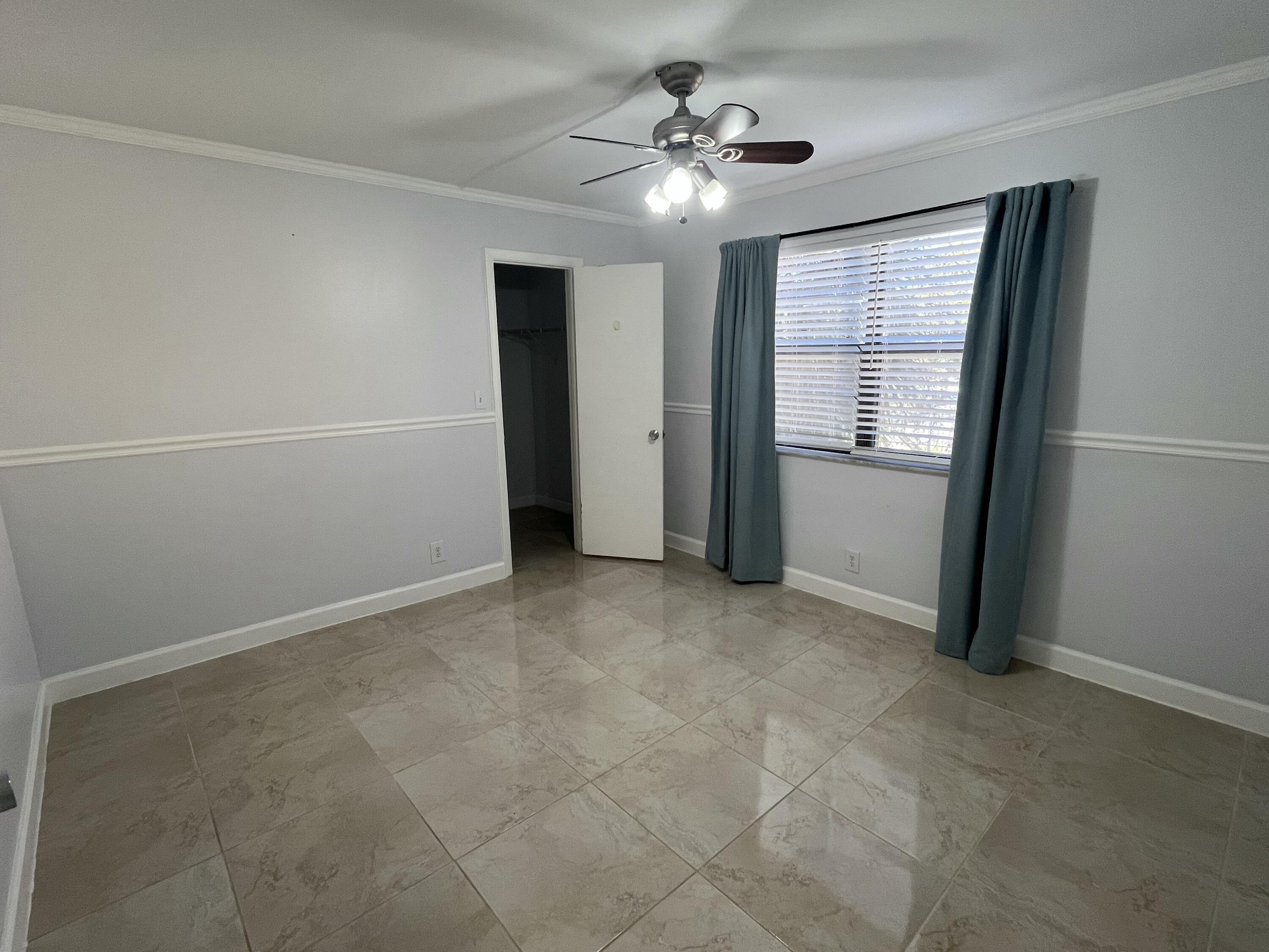 9300 Southwest 8th Street, Unit 301 Boca Raton, FL 33428 - Photo 11 of 27 an empty room with windows and fan