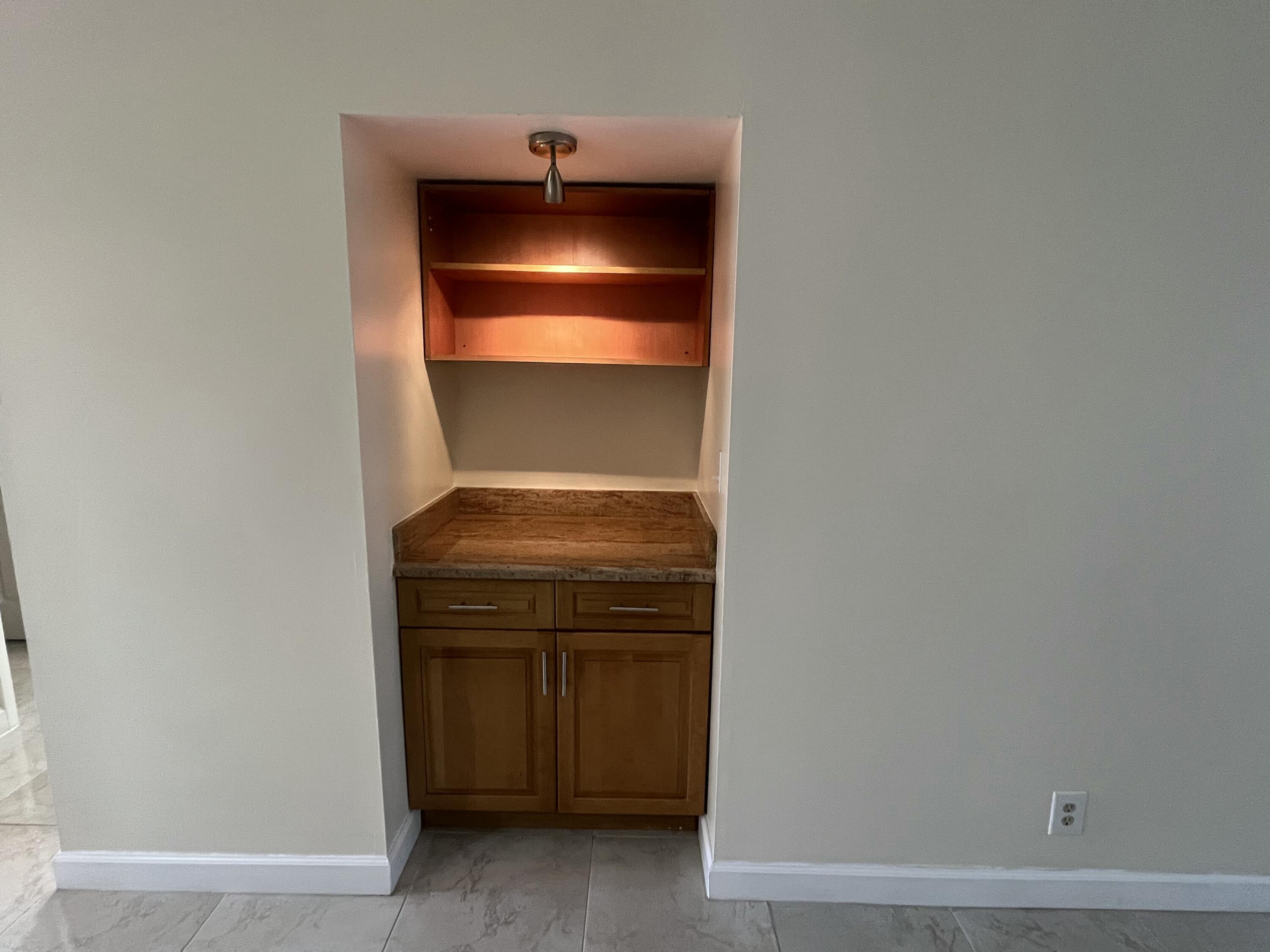 9300 Southwest 8th Street, Unit 301 Boca Raton, FL 33428 - Photo 8 of 27 a room with a fireplace and cabinets