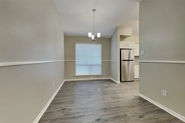 a view of a room with wooden floor kitchen appliances and a window