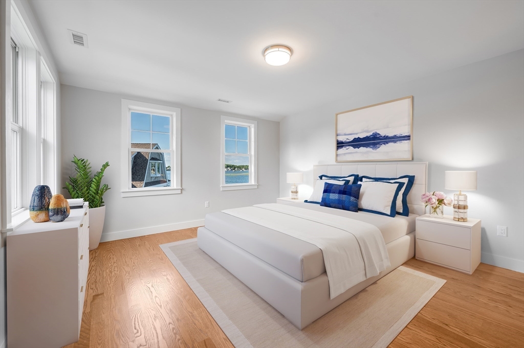 8 Riverside Road Gloucester, MA 01930 - Photo 27 of 40 a bedroom with a large bed wooden floor and windows