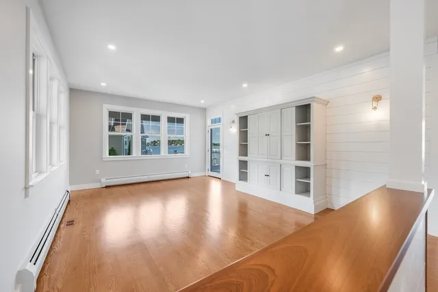 a view of empty room with wooden floor and windows