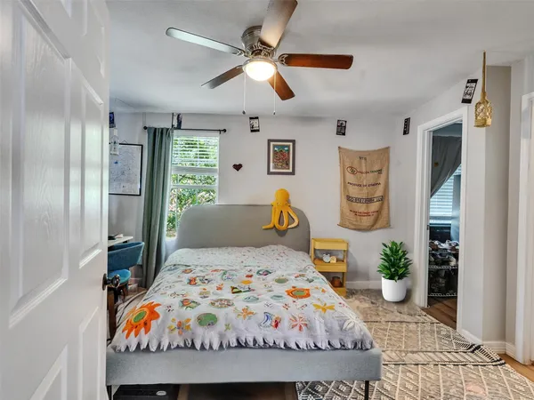 a bedroom with a bed a dresser and a chandelier