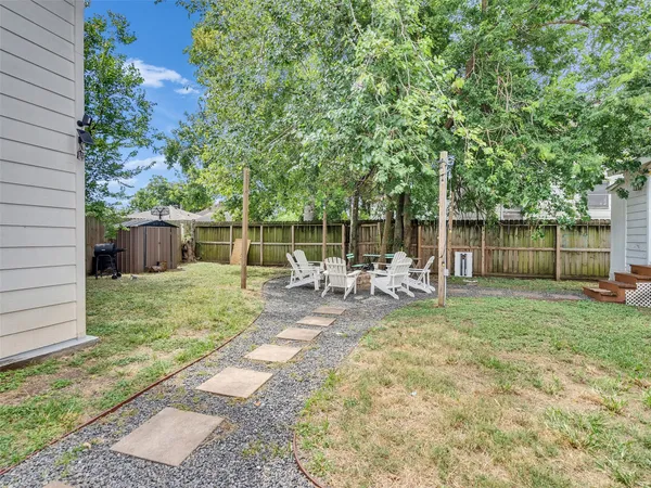 a view of a chair and table in backyard of the house
