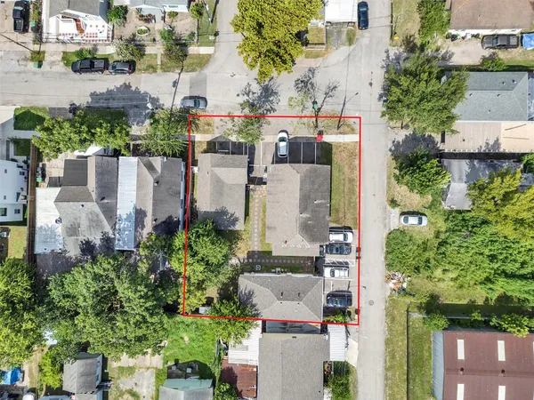 an aerial view of multiple houses with a yard