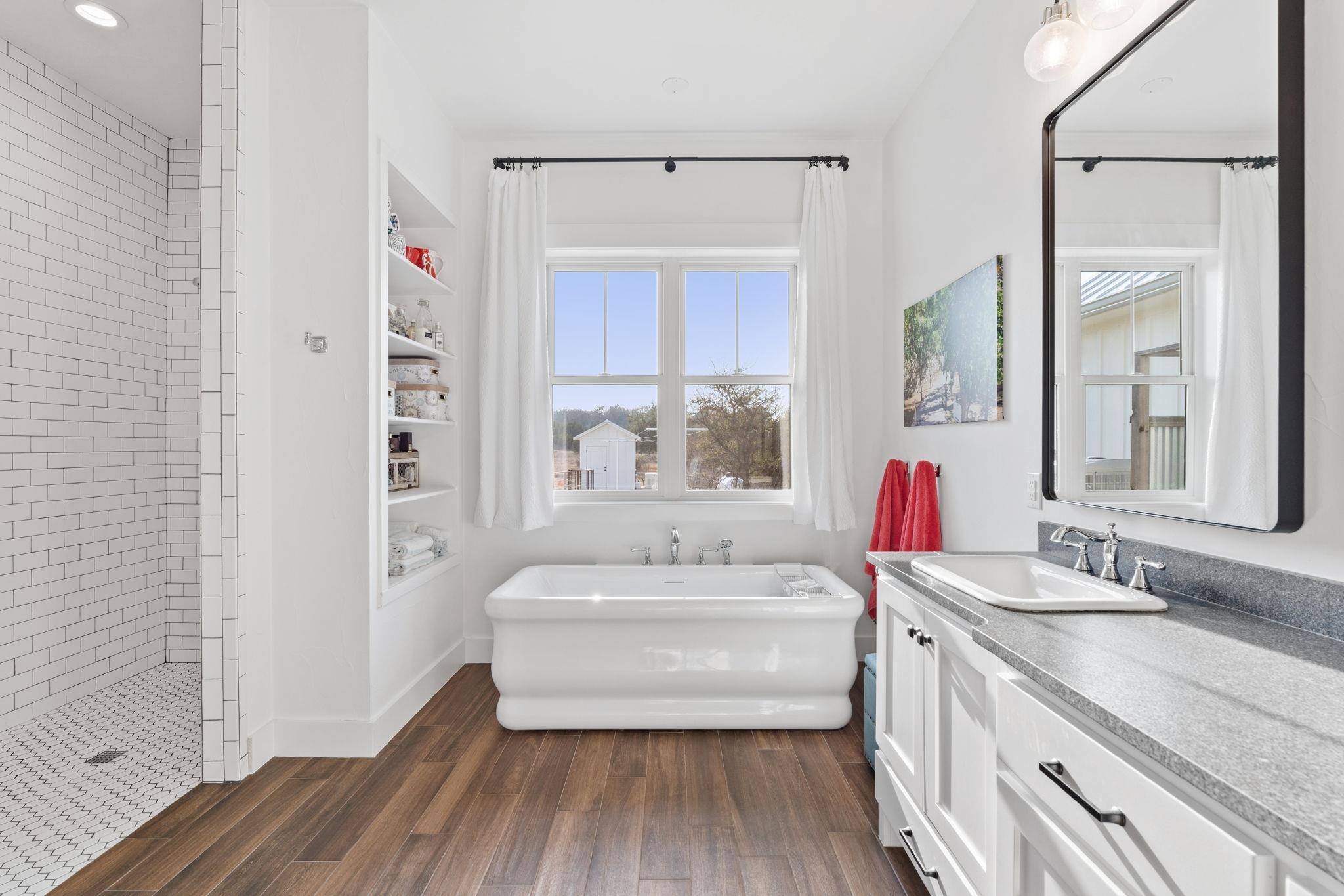 452 Southwick Ranch Road Johnson City, TX 78636 - Photo 11 of 30 a en suite bathroom with a granite countertop tub and a sink