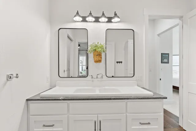 a bathroom with a granite countertop sink a mirror and a shower