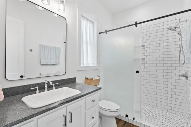 a bathroom with a granite countertop sink toilet and shower