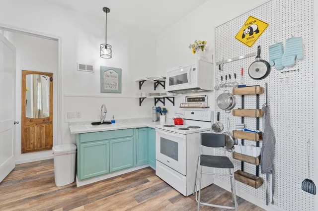 a utility room with cabinets and wooden floor