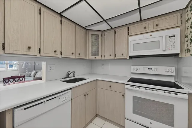 a kitchen with white cabinets and white appliances