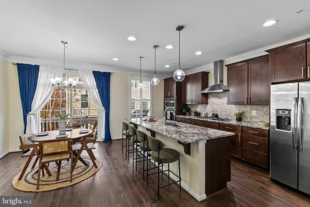 a kitchen with a table a stove and wooden floor