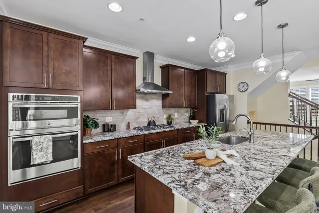 a kitchen with stainless steel appliances granite countertop a sink stove and cabinets