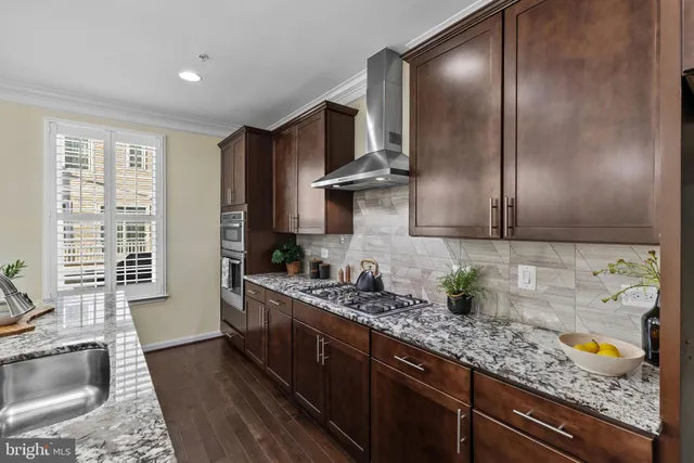 a dining room with wooden floor a chandelier a wooden table and chairs