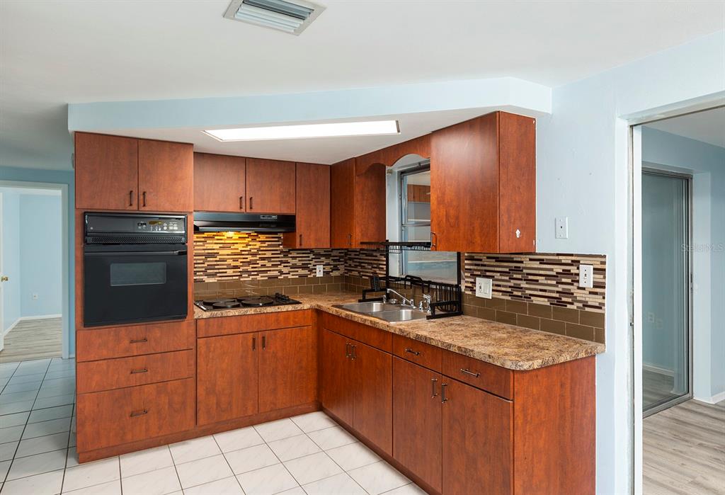 3128 Kilburn Road Holiday, FL 34691 - Photo 8 of 28 a kitchen with stainless steel appliances granite countertop a sink stove and cabinets