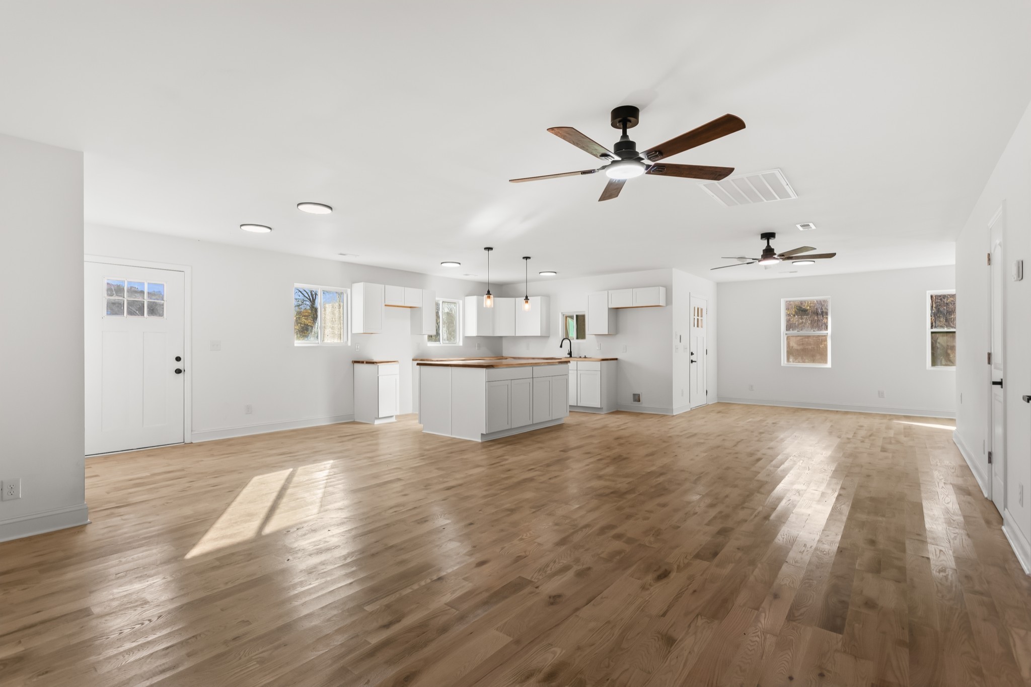 a view of a kitchen with wooden floor and a ceiling fan