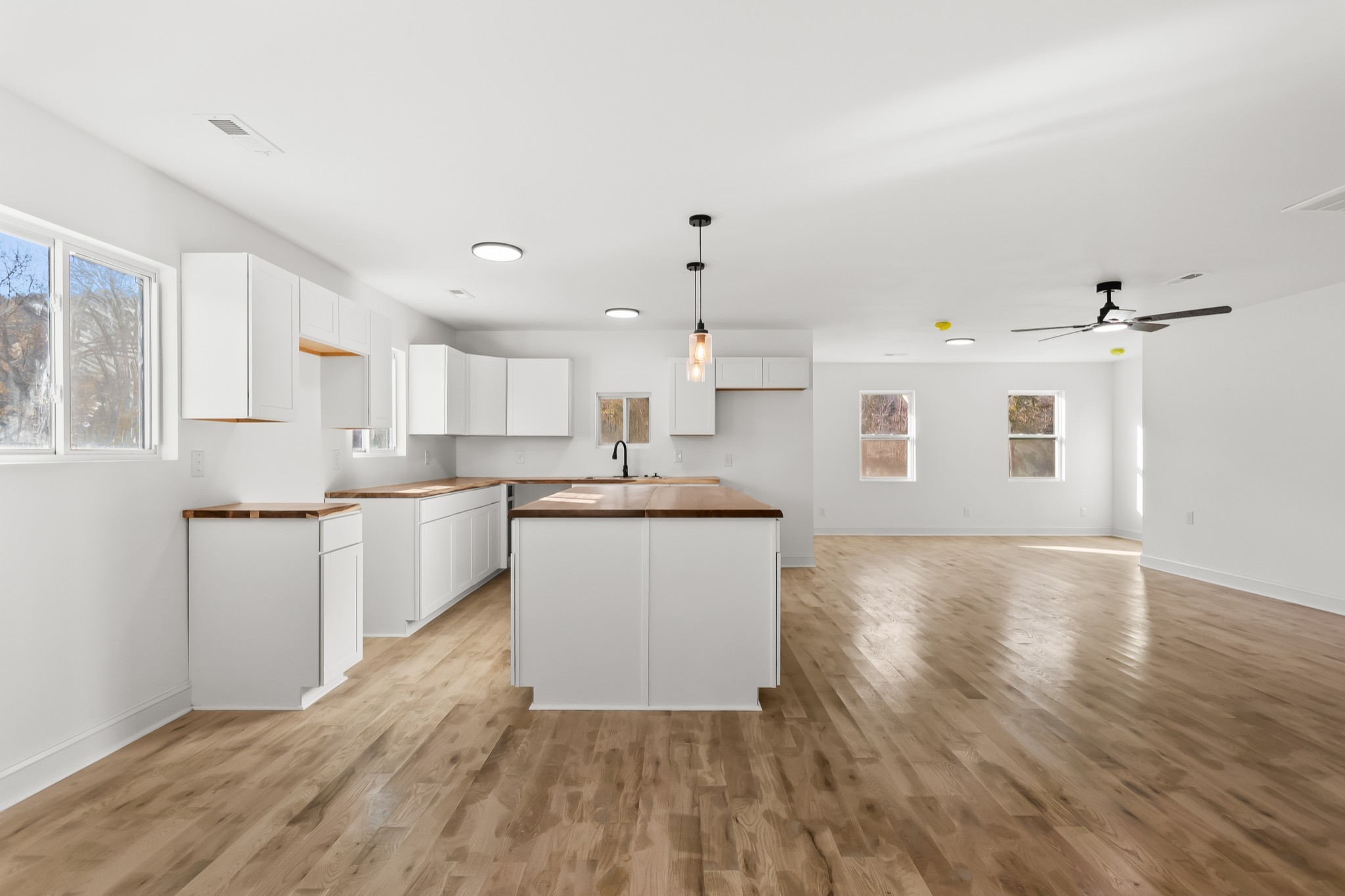 8637 Dog Branch Road Mount Pleasant, TN 38474 - Photo 6 of 41 a large white kitchen with kitchen island a sink wooden floor and a refrigerator
