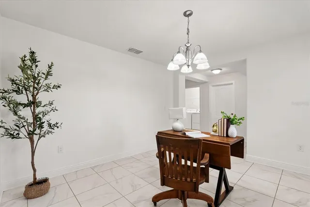 a dining room with chandelier and window