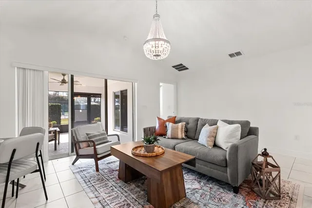 a living room with furniture a table and a large window