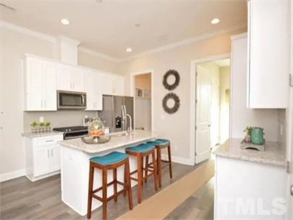 a living room with furniture kitchen view and a wooden floor