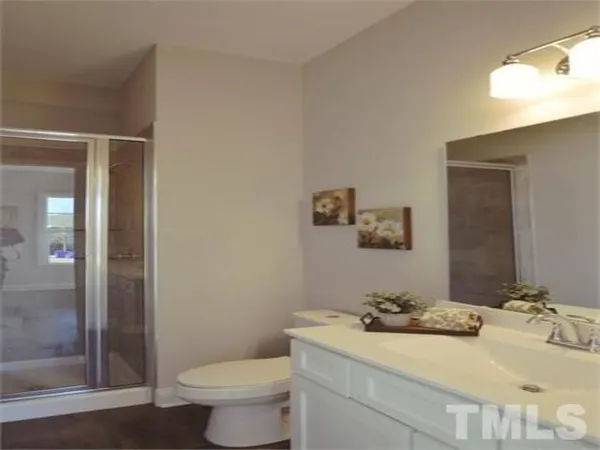 a bedroom with a bed table chair and window